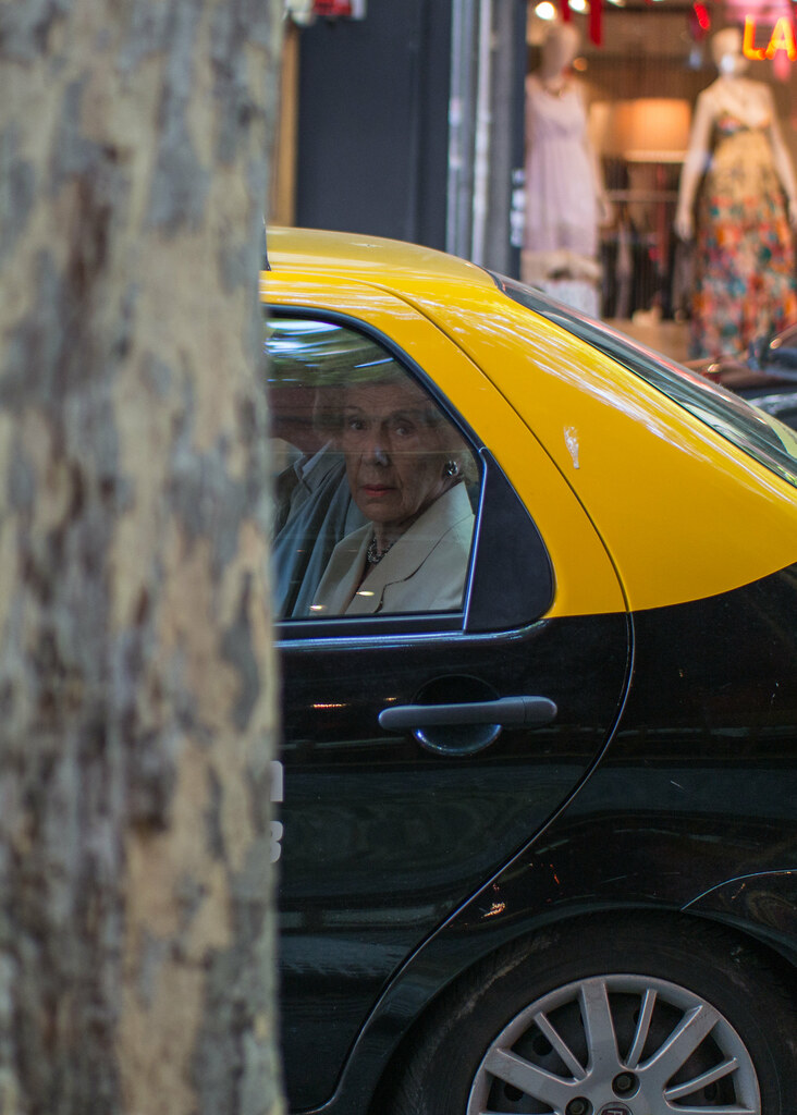 Real photo of an elderly passenger seated in a taxi for comfort planning context